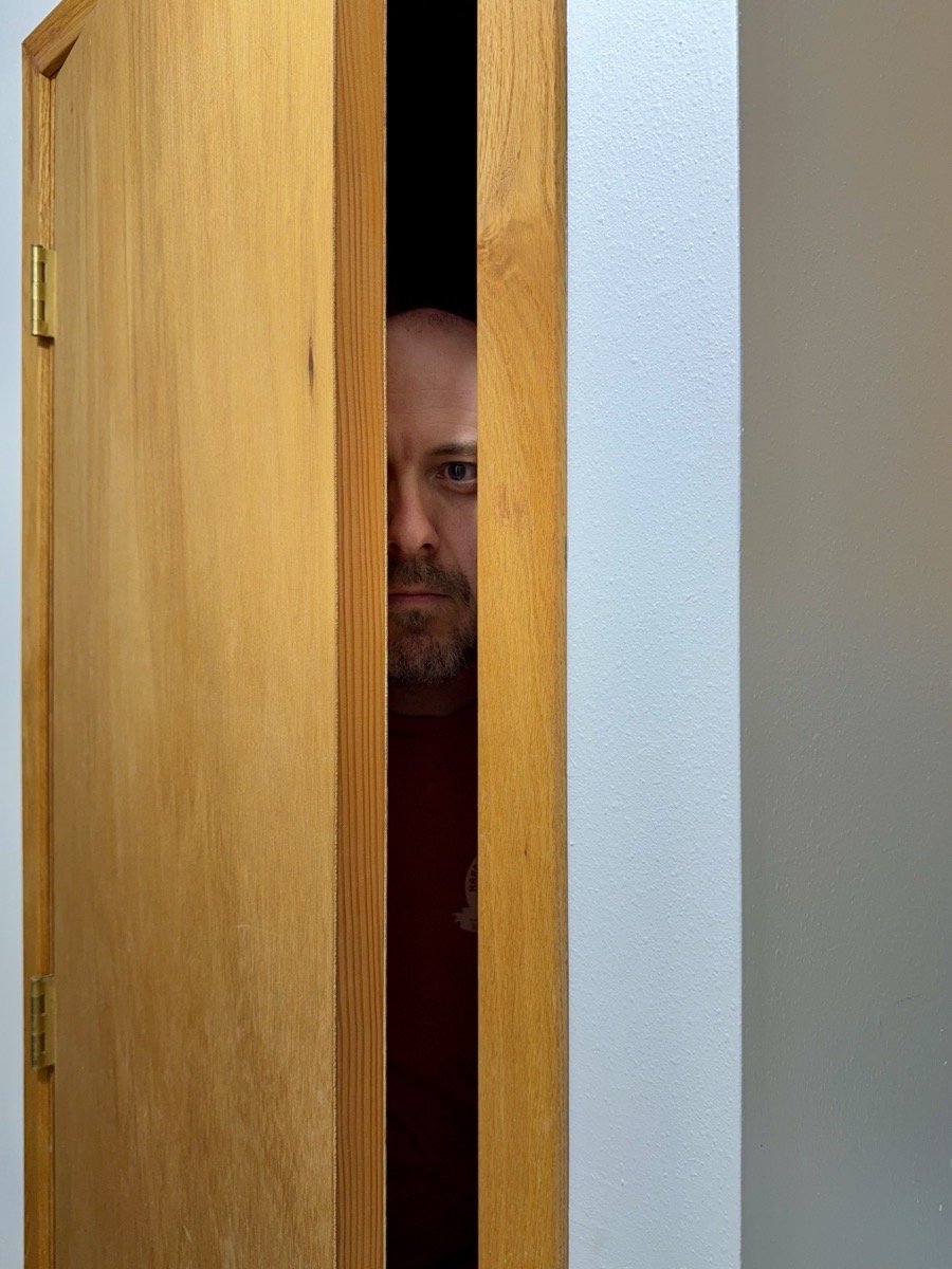 Person hiding behind a door