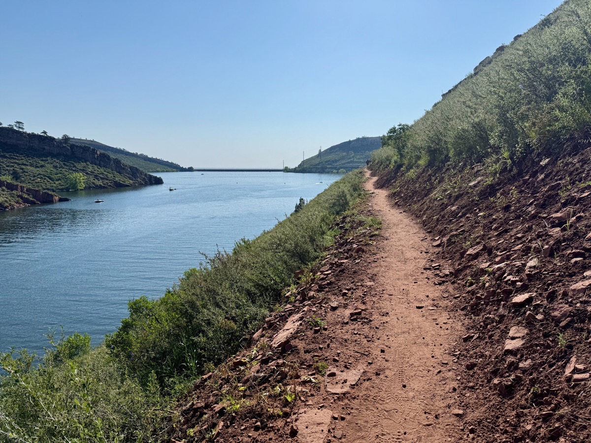 A trail on a hillside next to a lake